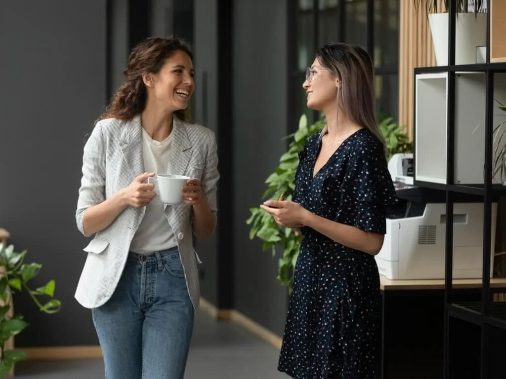 Two women talking in an office.