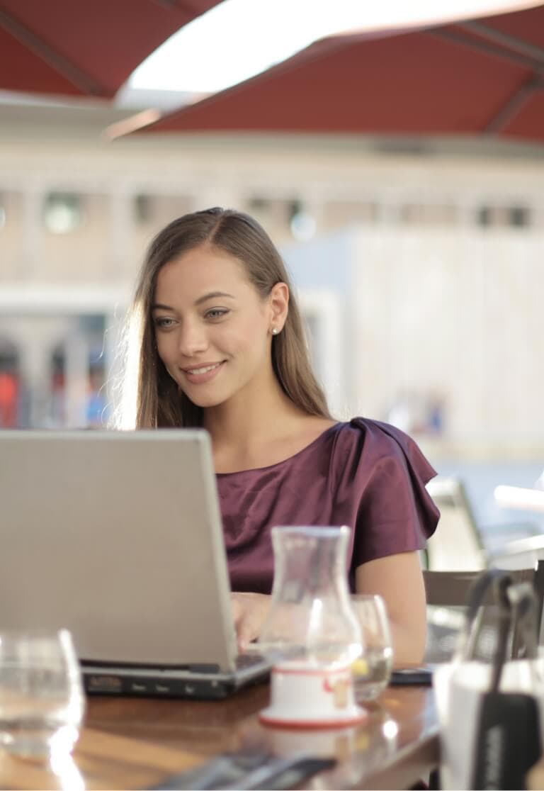 A woman sitting at a table with a laptop.
