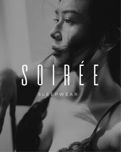 A black and white photo of a woman in lingerie.