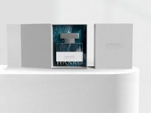 A bottle of perfume sitting on top of a white box.