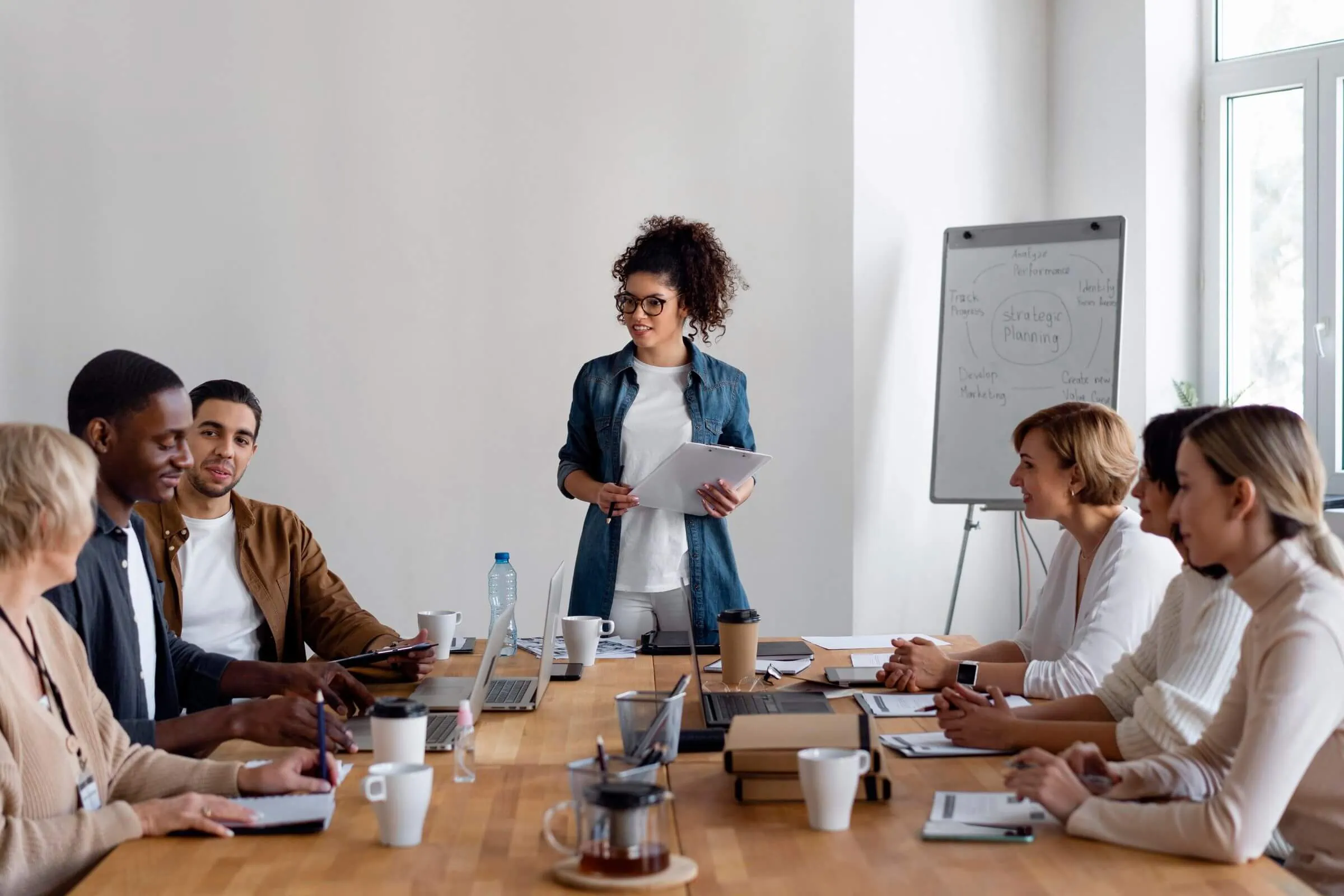 A woman presenting a PPC campaign to a group at a conference table.