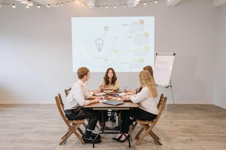 A group of people from a social media marketing agency sitting around a table in a meeting room.
