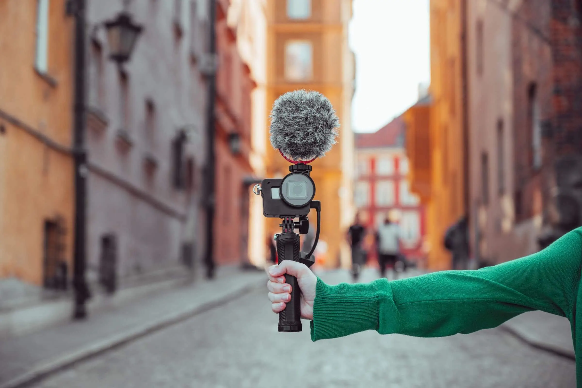 A woman displaying inbound marketing skills by holding a microphone in an alleyway.